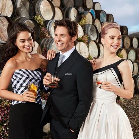 James Marsden, Suki Waterhouse, and Shanina Shaik pose in elegant outfits among Scotch whisky barrels for International Scotch Day, styled by Angela Moffat in Edinburgh, Scotland.